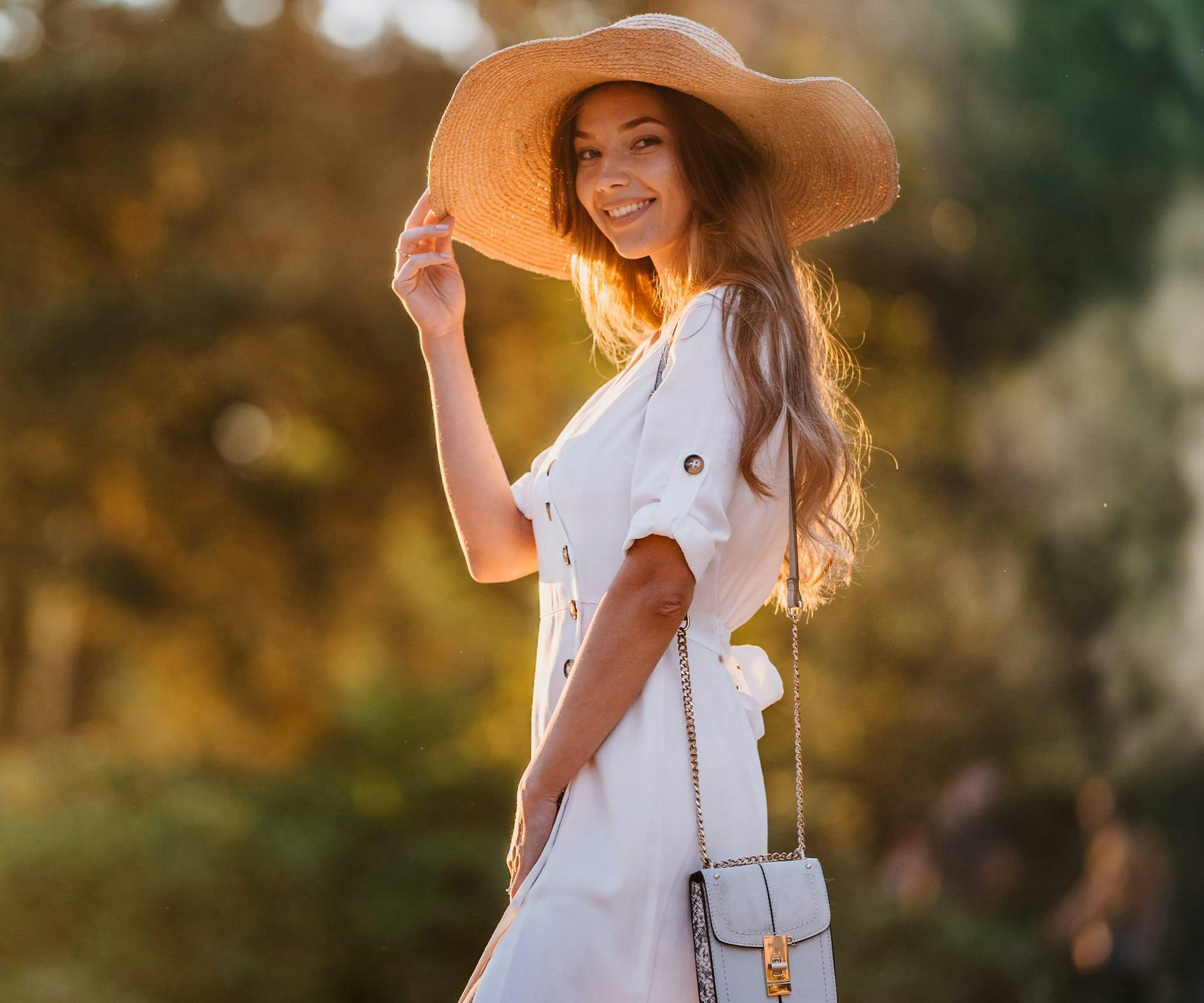 woman in white outside with summer hat