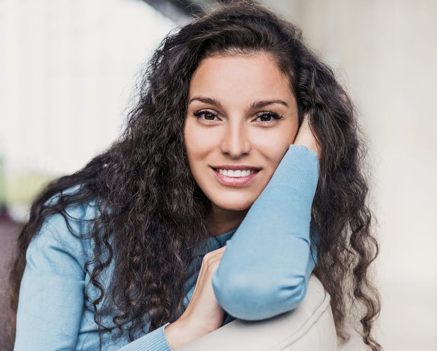 woman with curly hair in blue shirt