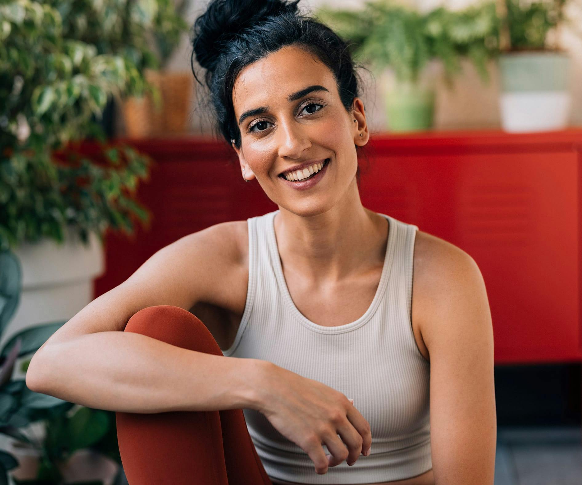 woman in tanktop with her hair in a bun