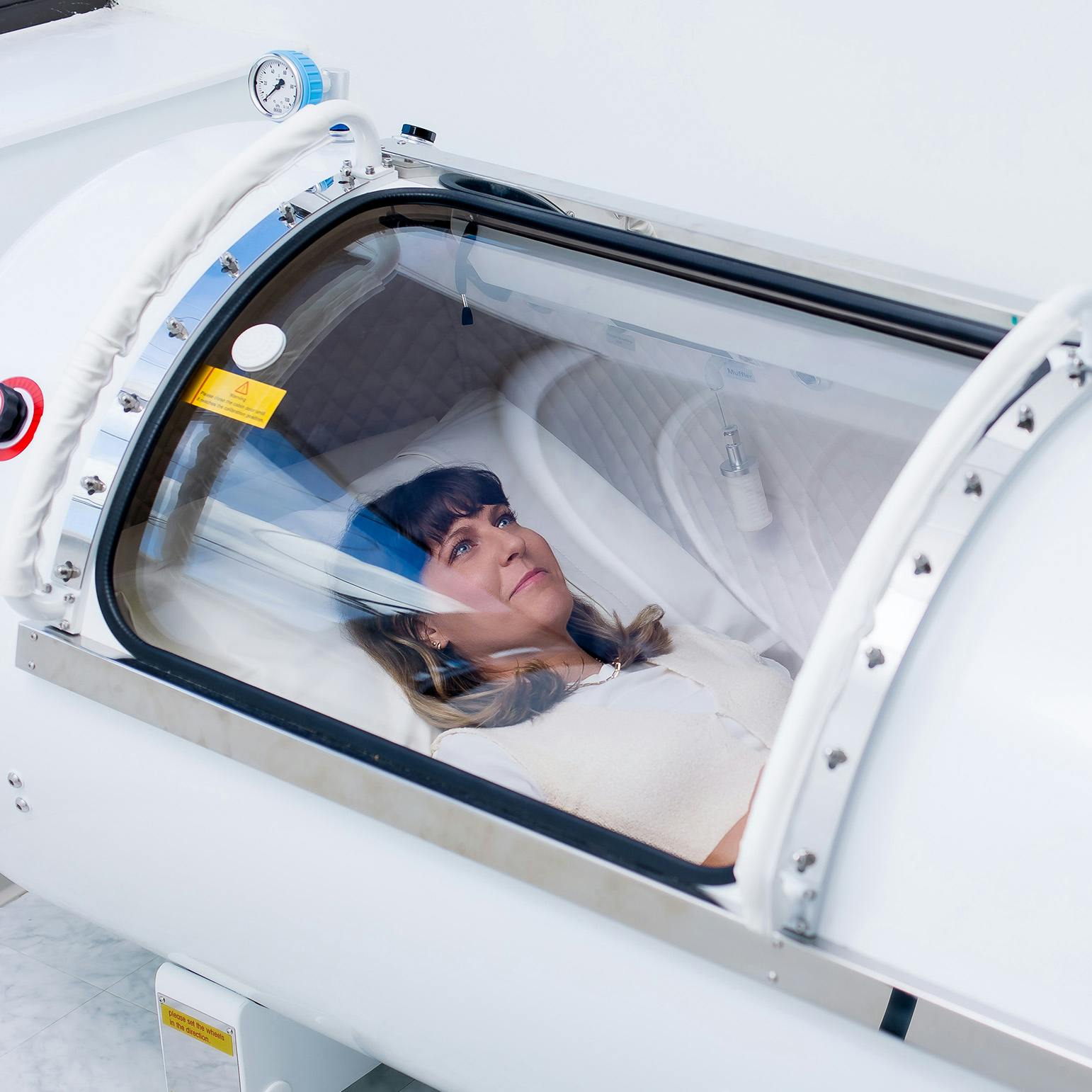 woman inside of an oxygen therapy tank