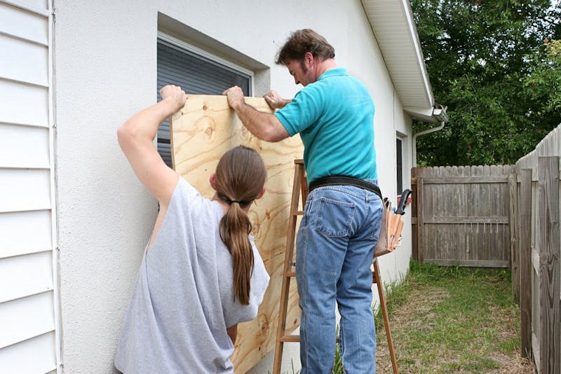 people boarding up a window