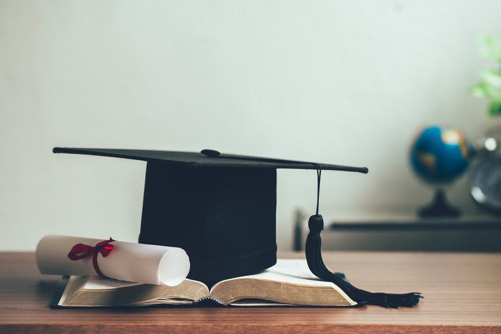 graduation cap on top of book