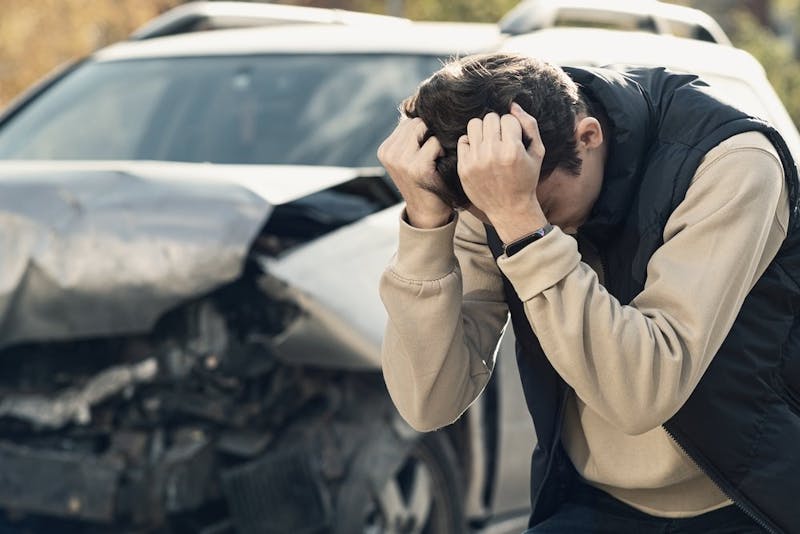 distraught man in front of car crash