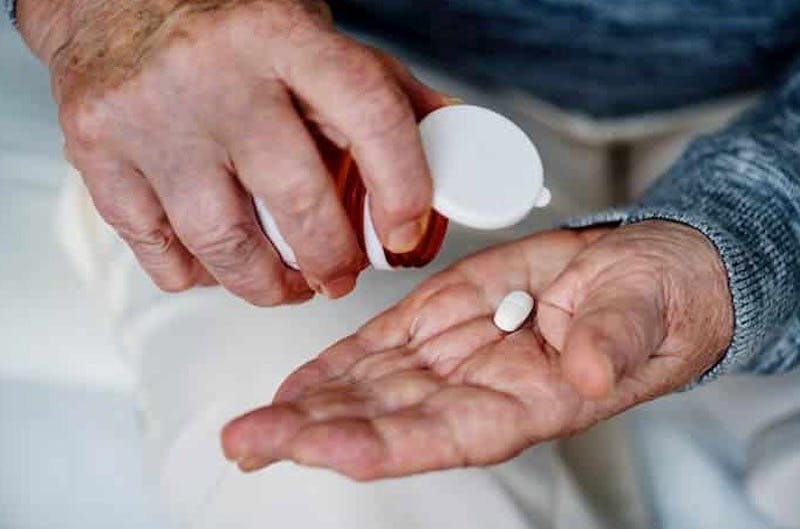 man with pill in hand