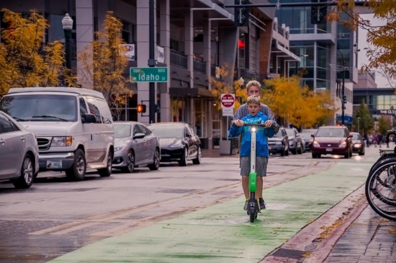 two boys riding electric scooter