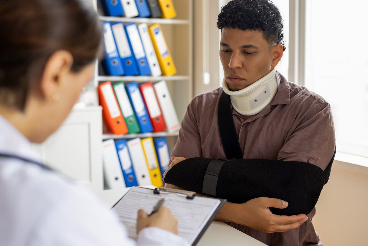 man wearing a neck brace and an arm sling