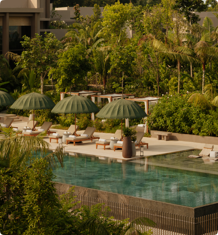 Infinity swimming pool surrounded by tropical greenery