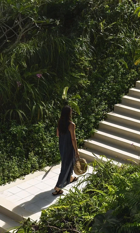 Women walking up stairs through a luxury resort filled with tropical greenery