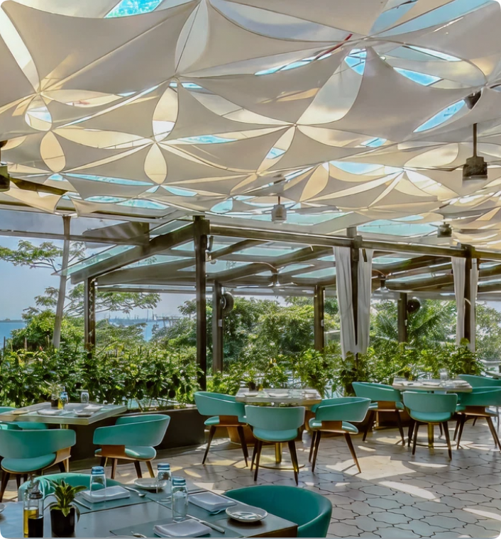 Outdoor dining restaurant with light blue chairs and sun shades