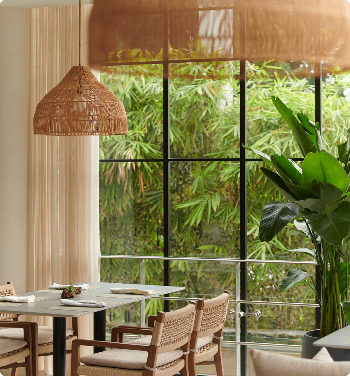 Restaurant with boho aesthetic with a large window overlooking greenery