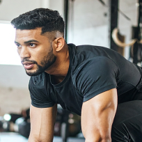 Asian man with muscular arms in a gym