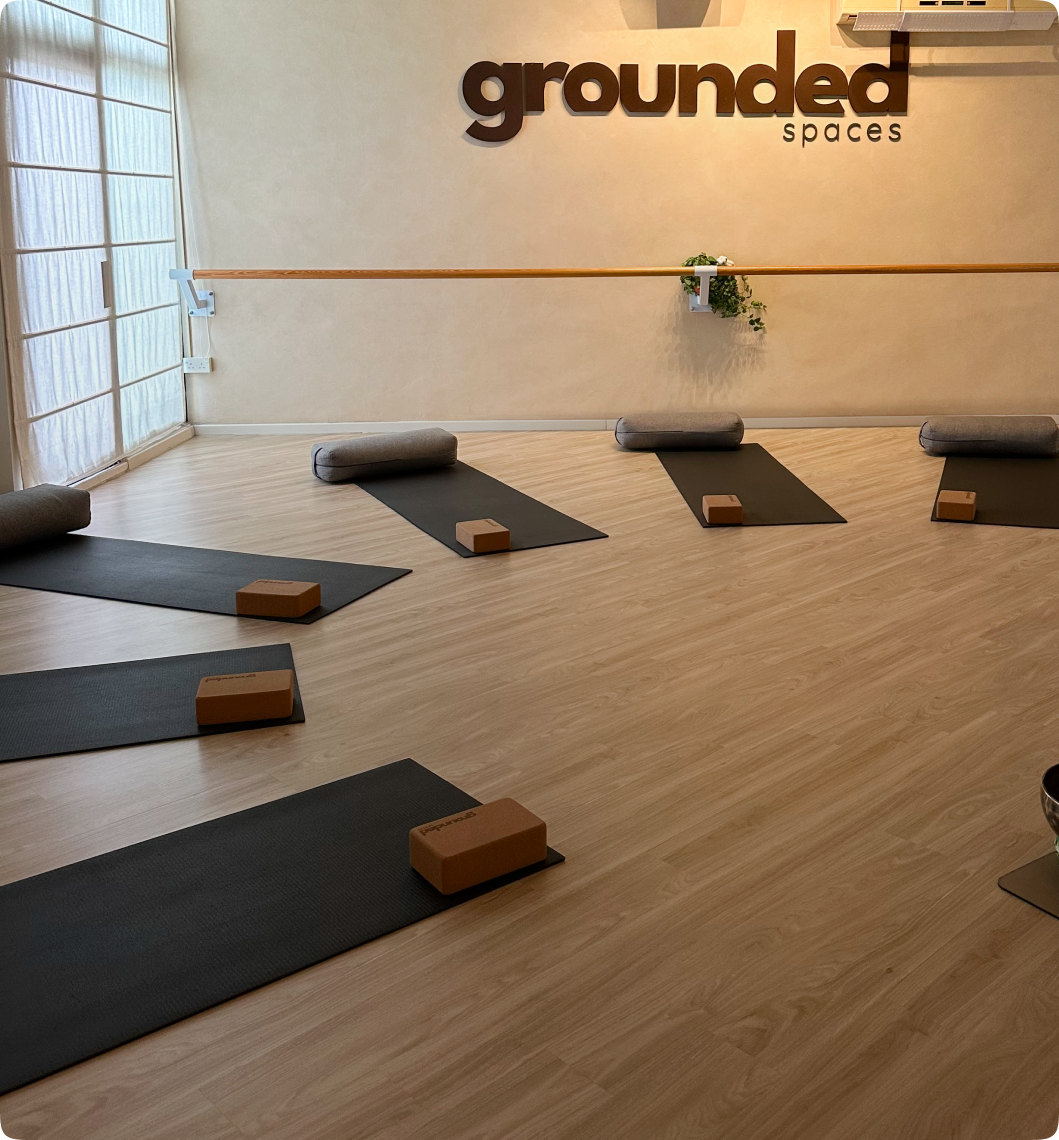 Yoga studio with black mats and wooden floor
