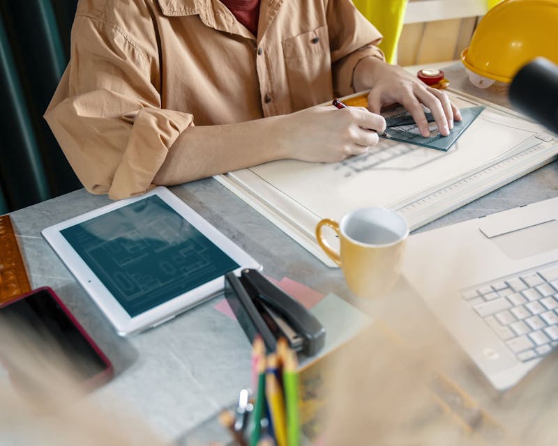 man at laptop working on blueprints