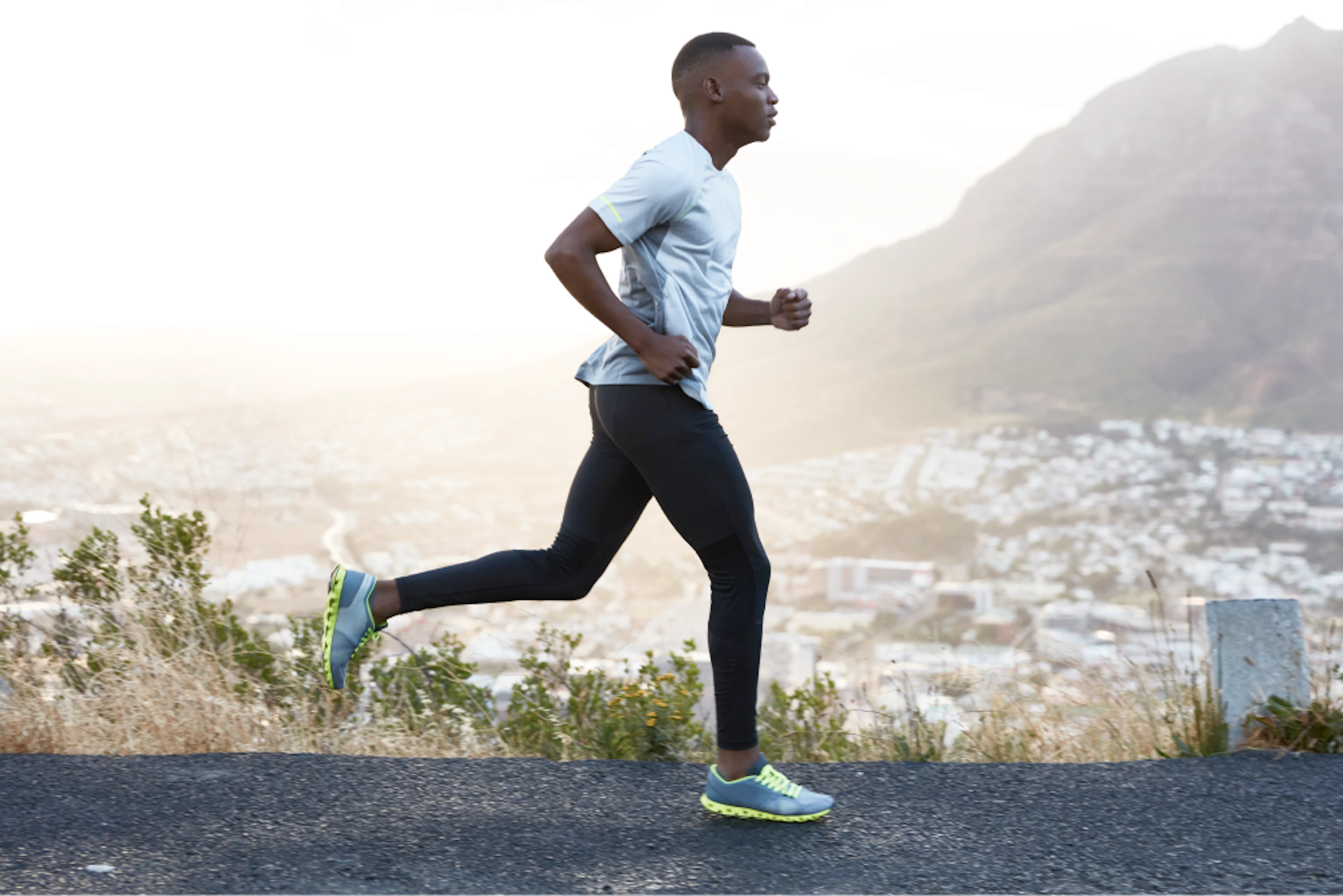 outdoor shot active dark skinned man running morning has regular trainings dressed tracksuit comfortable sneakers concentrated into distance sees finish far away 1