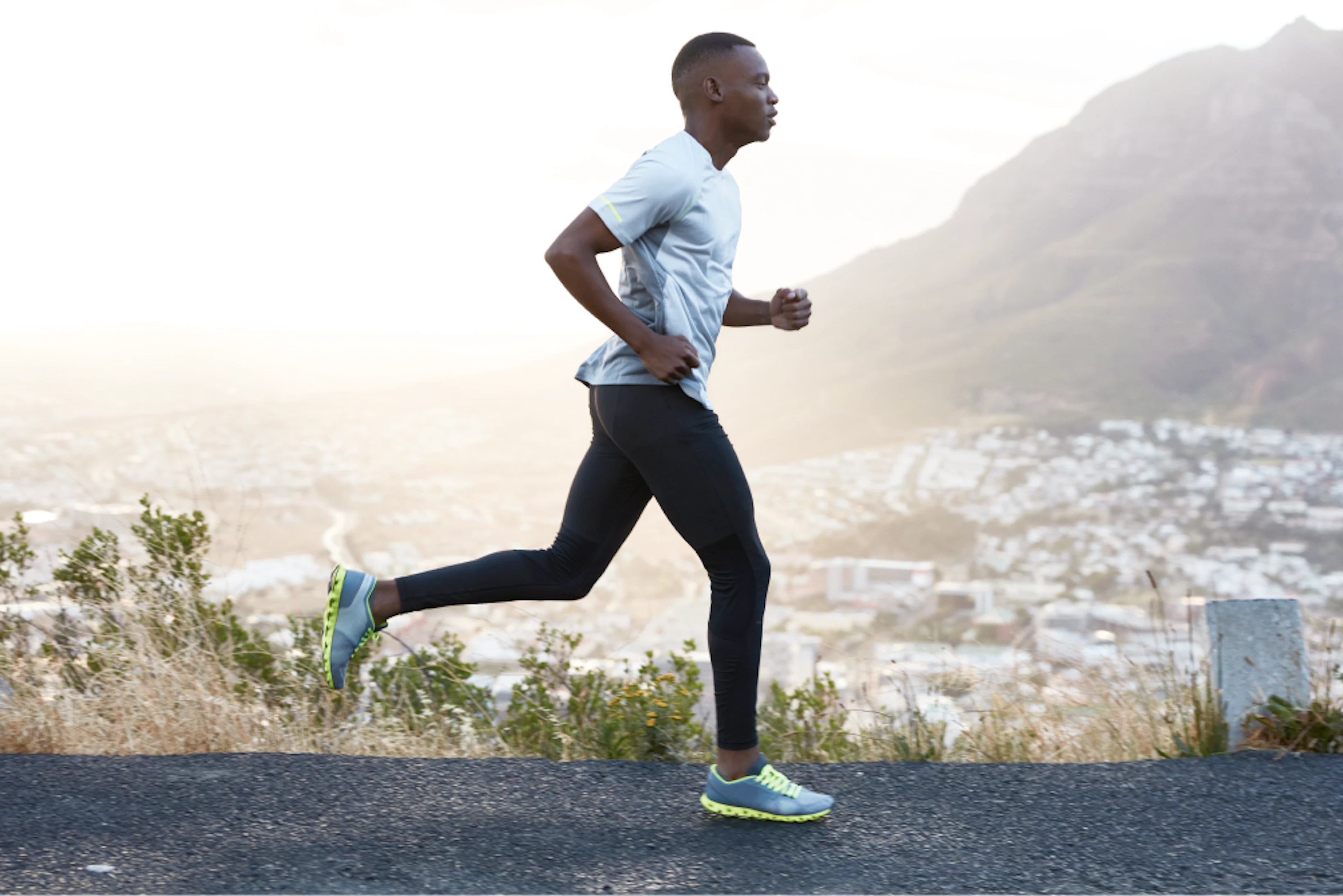 outdoor shot active dark skinned man running morning has regular trainings dressed tracksuit comfortable sneakers concentrated into distance sees finish far away 1