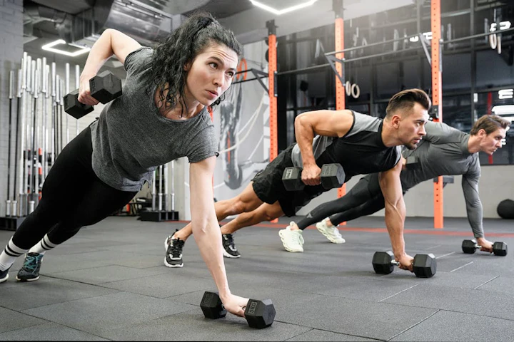 people working out indoors together with dumbbells 1