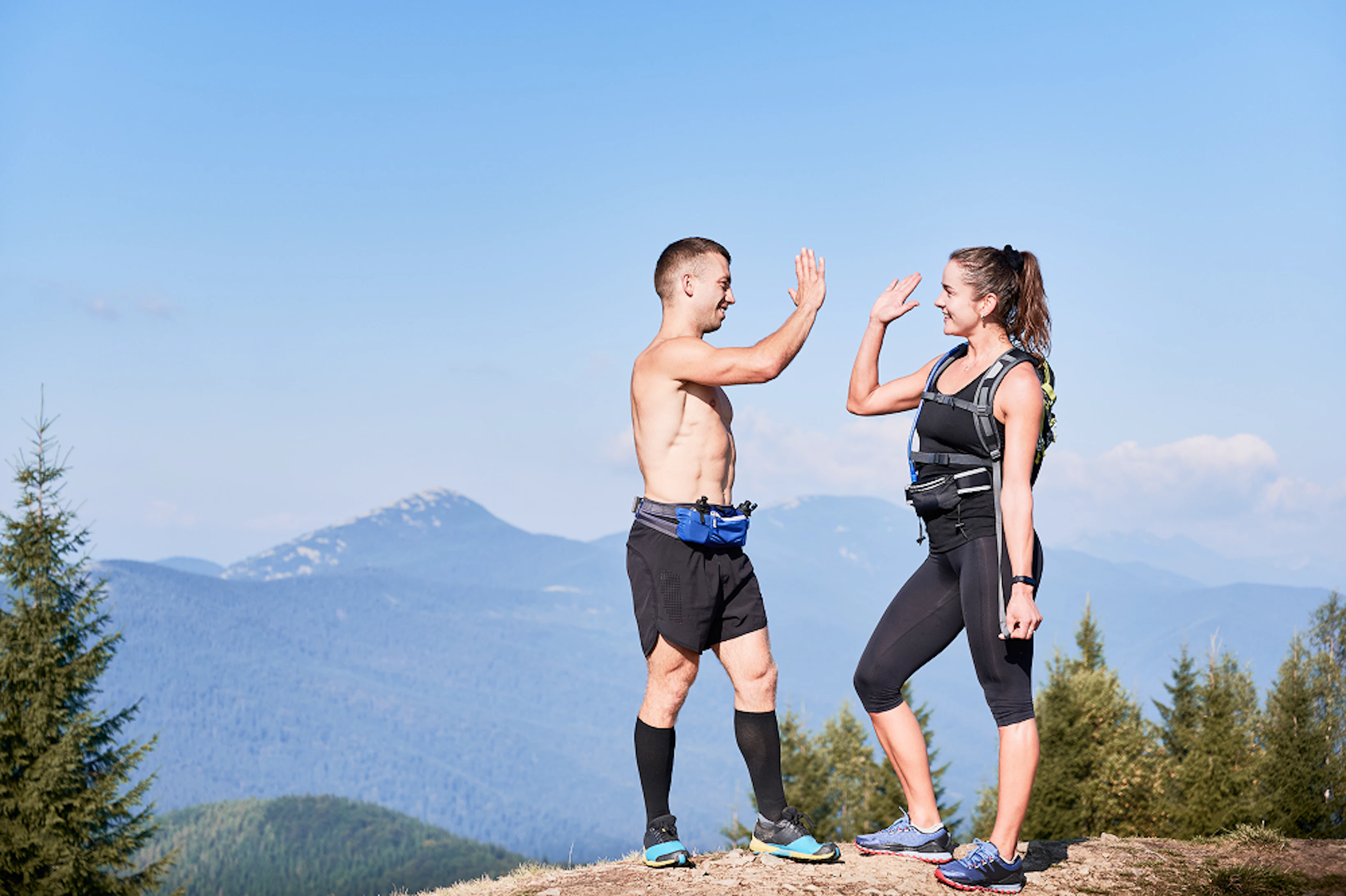 couple athletic smiling friends standing top mountain hill 1