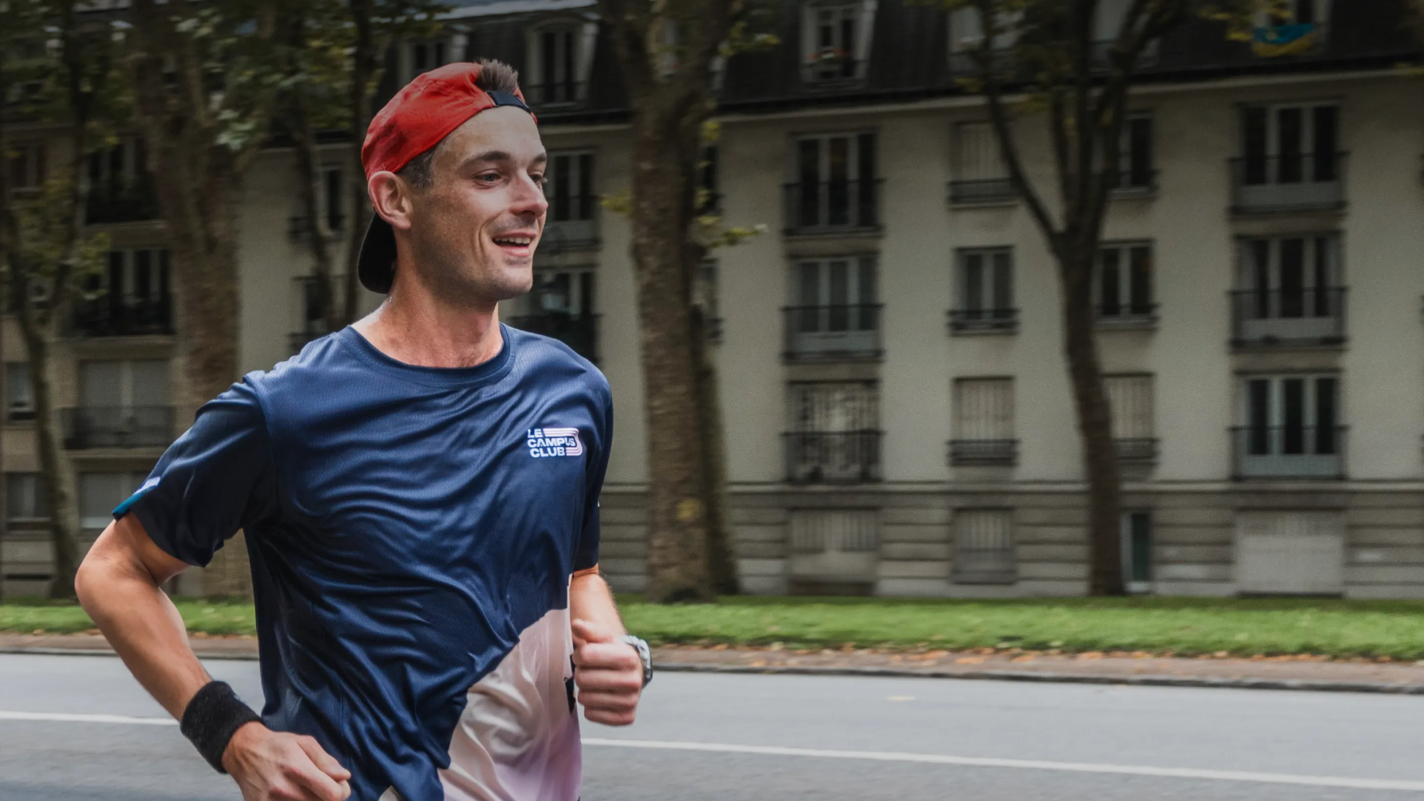 un homme court avec le sourire. Il porte un t-shirt campus club.