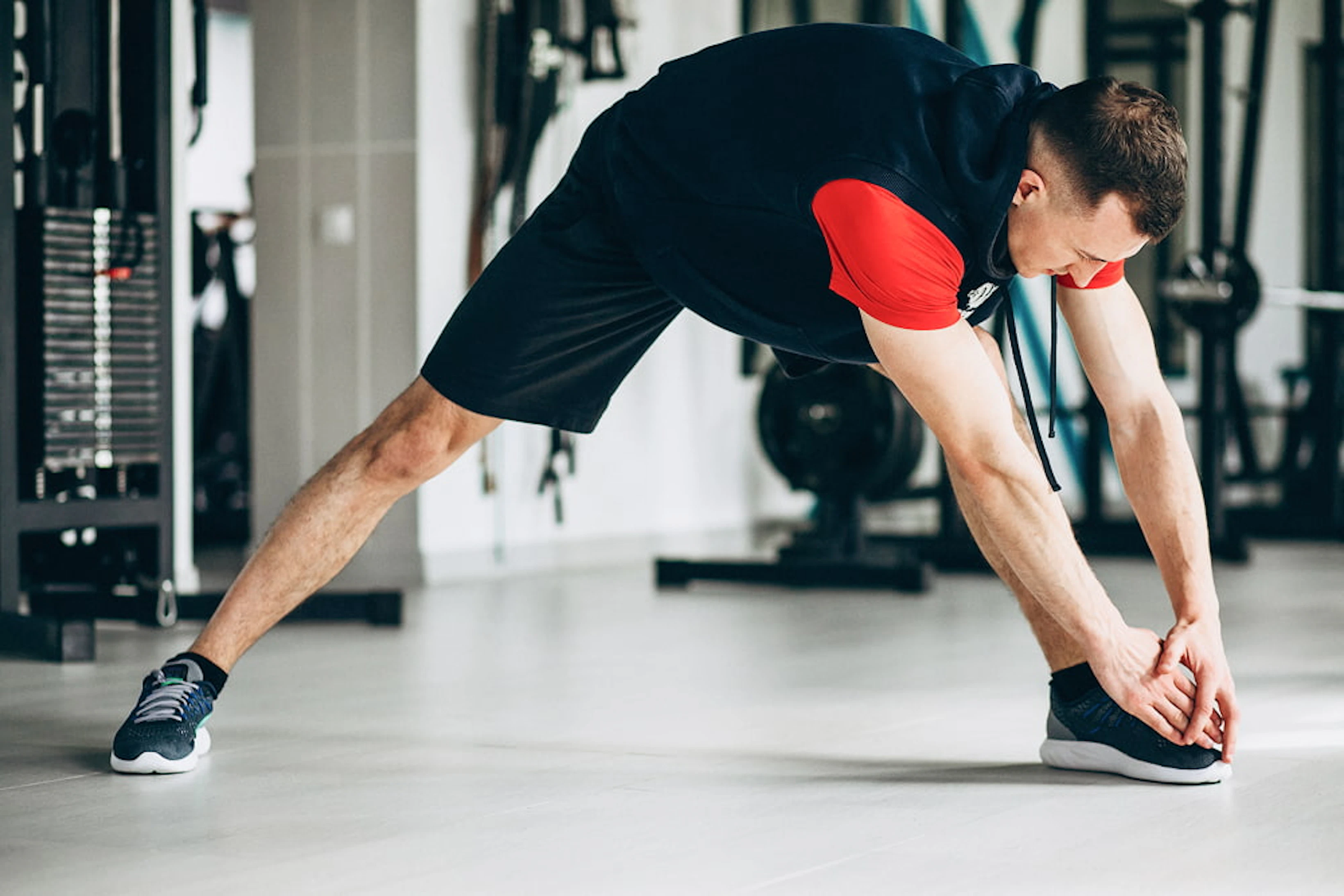 young fitness trainer stretching gym 1