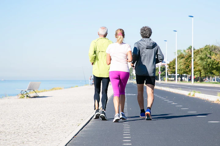 back view mature joggers sports clothes running track along river bank full length copy space activity healthy lifestyle concept 1
