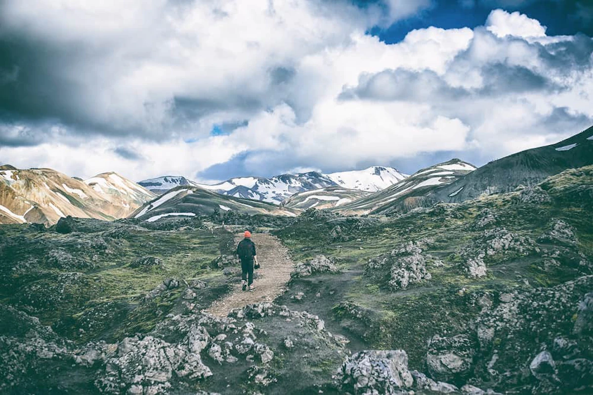 person black suit walking brown road 1