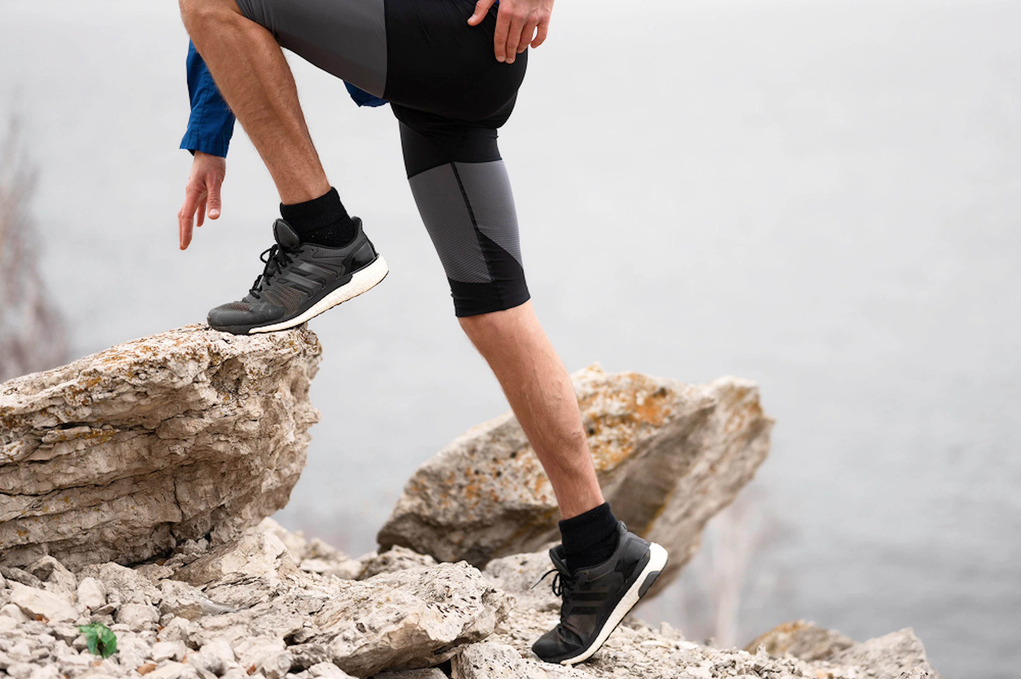 jambes d'homme escaladant une roche