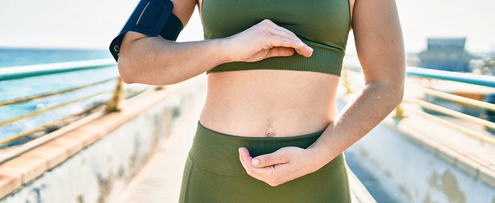 sportswoman wearing sportswear with hands stomach city 1 1