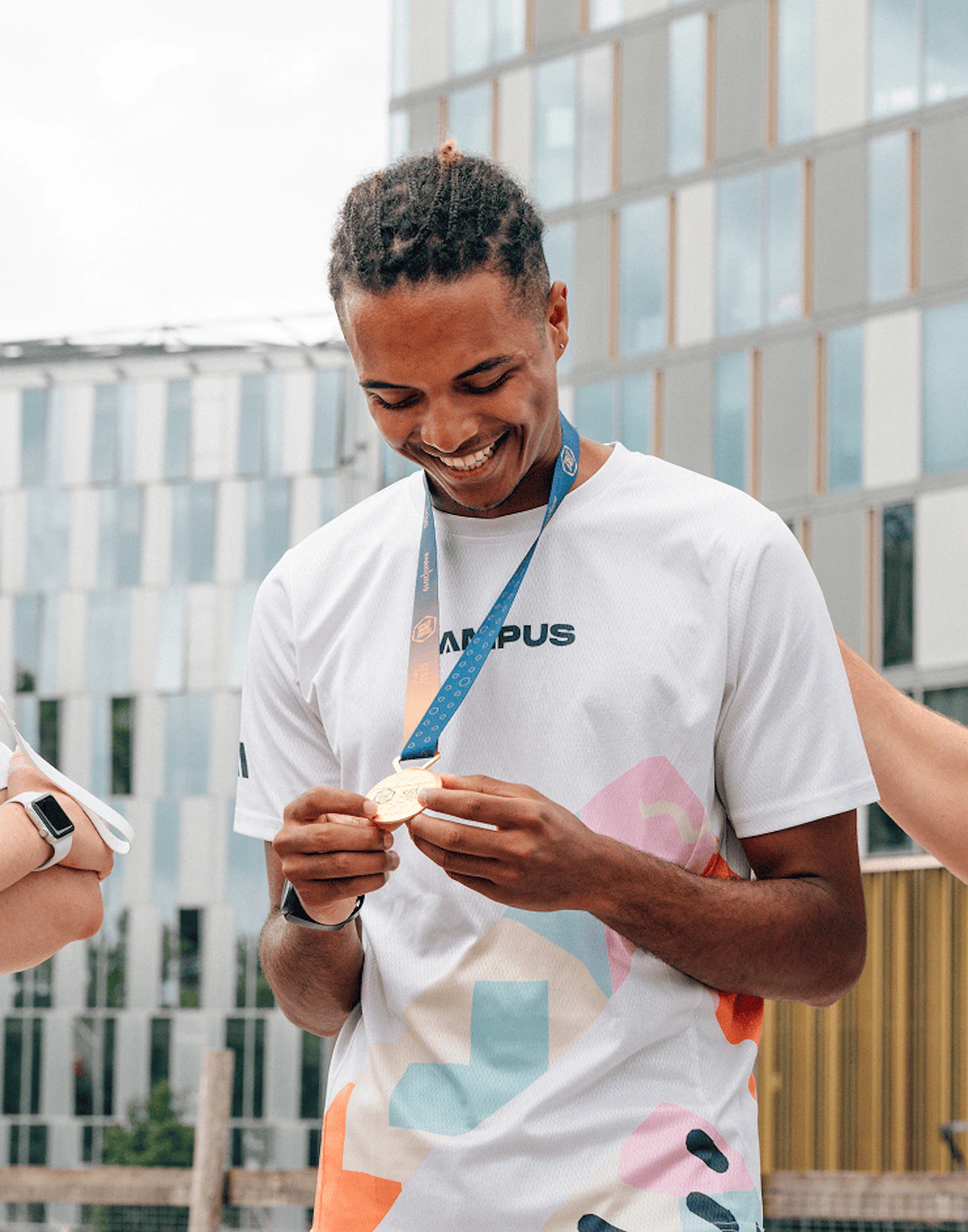 Coureur en train d'admirer sa médaille autour du cou