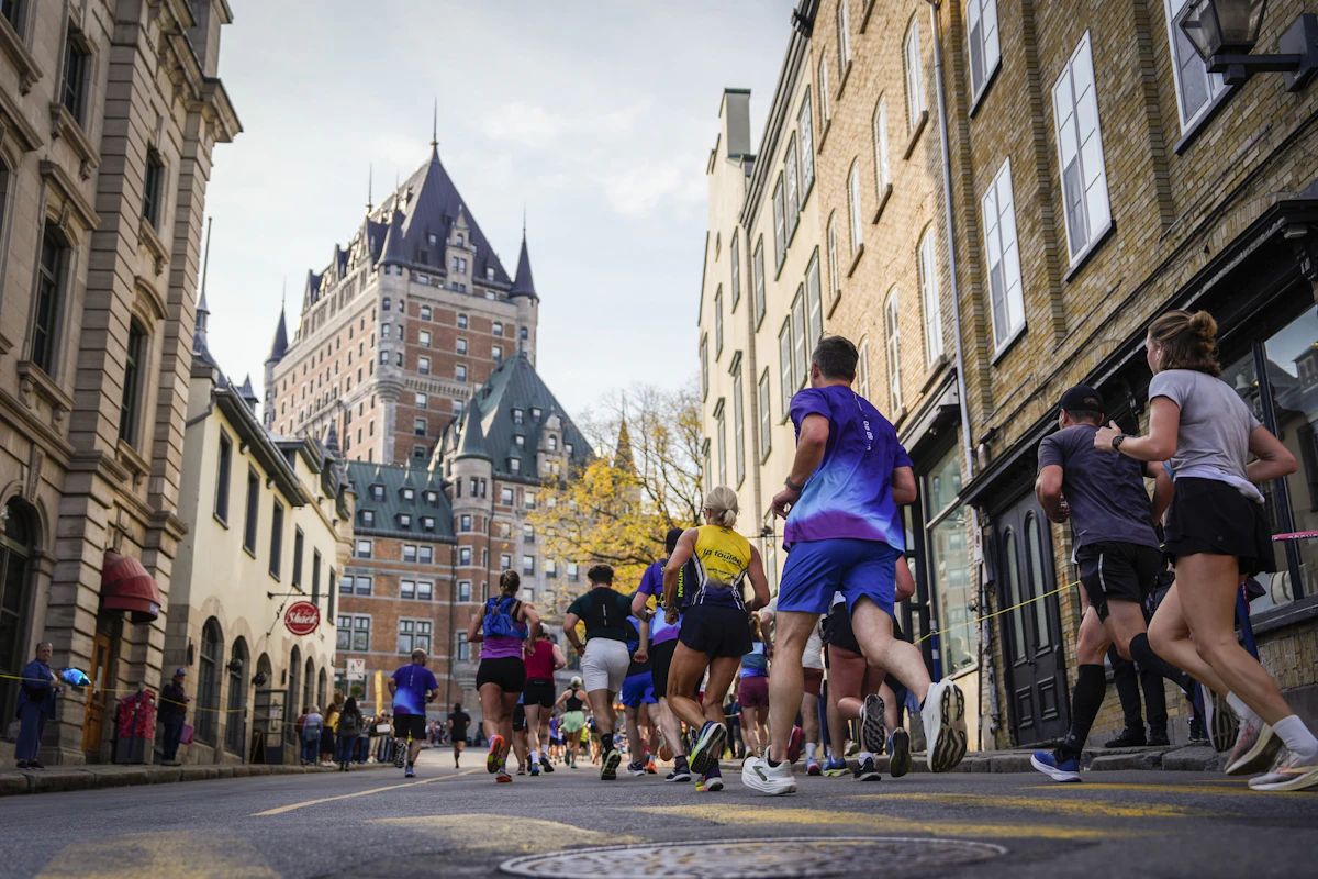 Des coureurs courent dans une rue vers le château Frontenac, à Québec