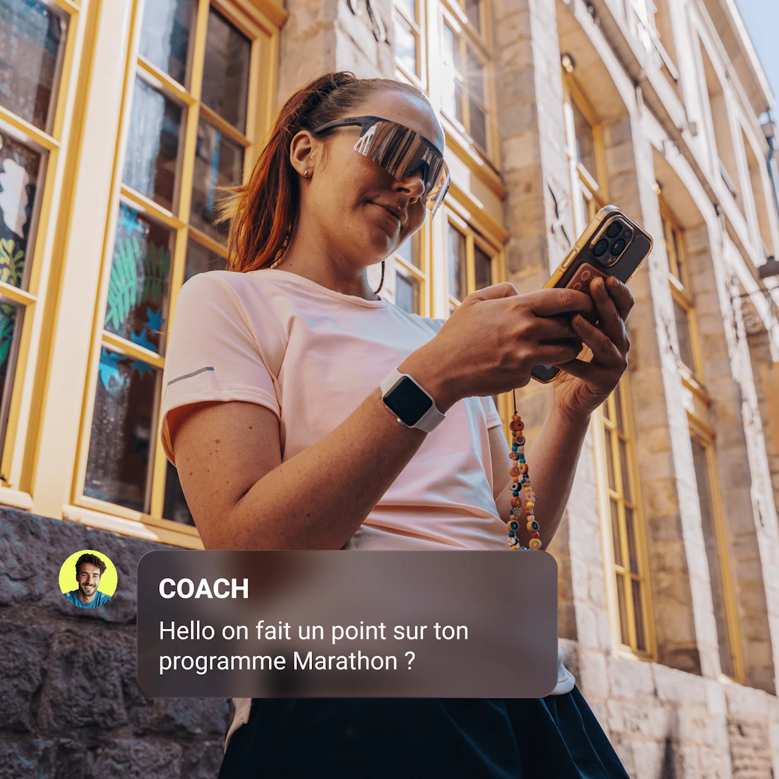 Coureuse habillée en tenue de running utilisant son smartphone
