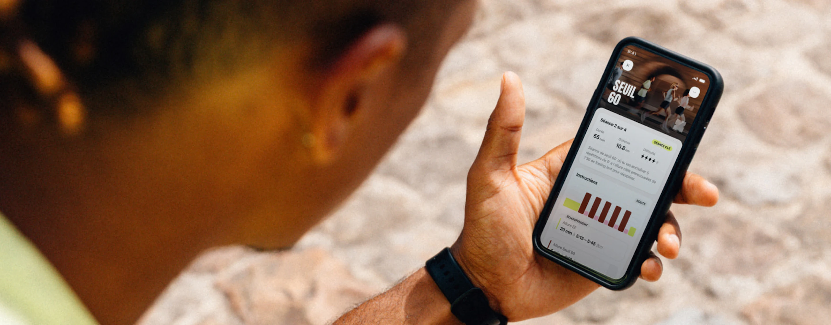 Coureur assis en train de lire sa séance du jour sur l'application Campus Coach