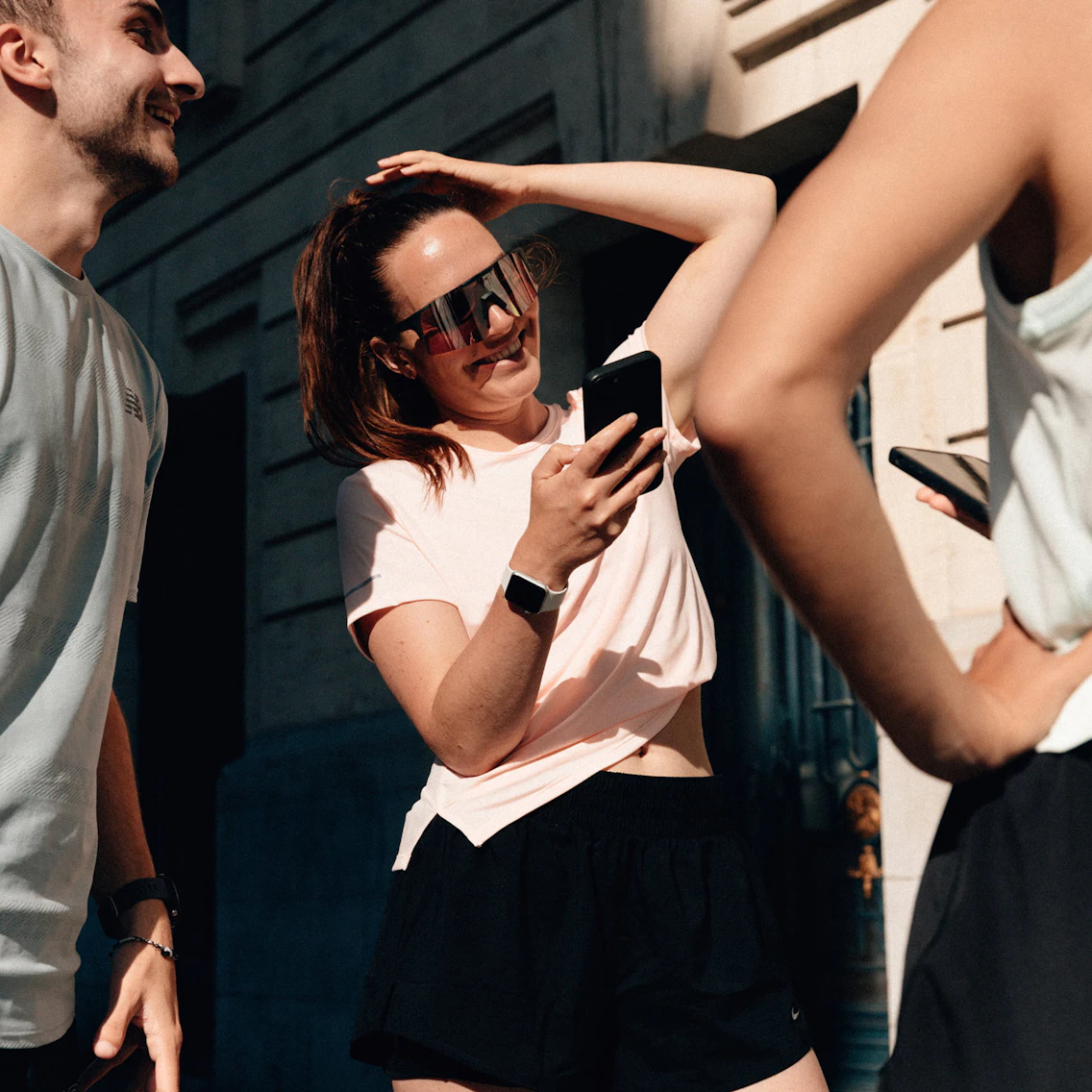 Coureuse souriante utilisant l'application Campus Coach sur son smartphone