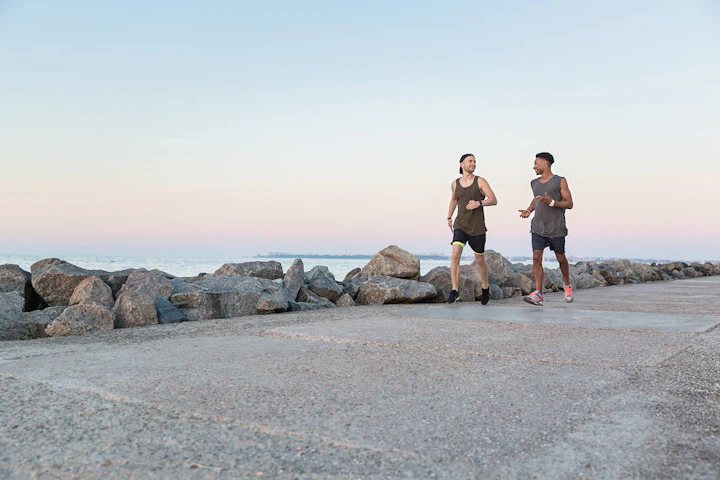 deux hommes courent en discutant au bord de la mer