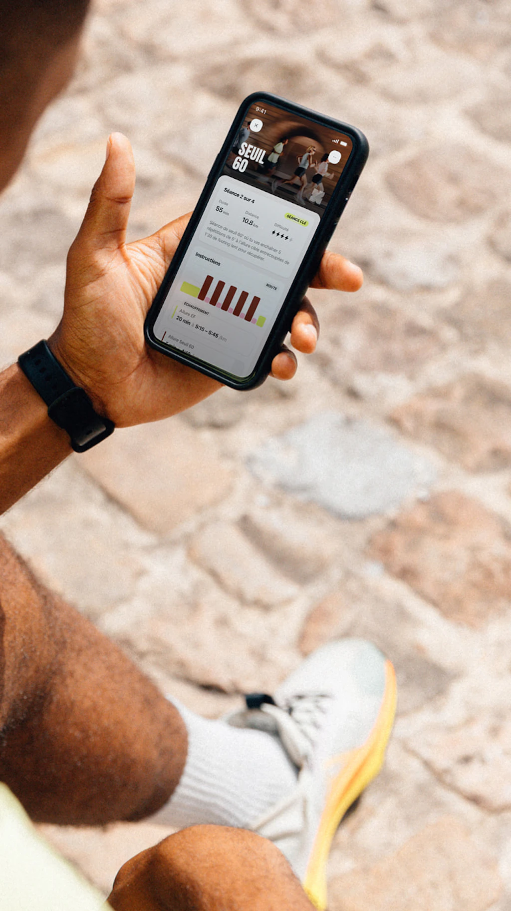 Coureur assis utilisant l'application Campus Coach pour visualiser sa séance de seuil 60