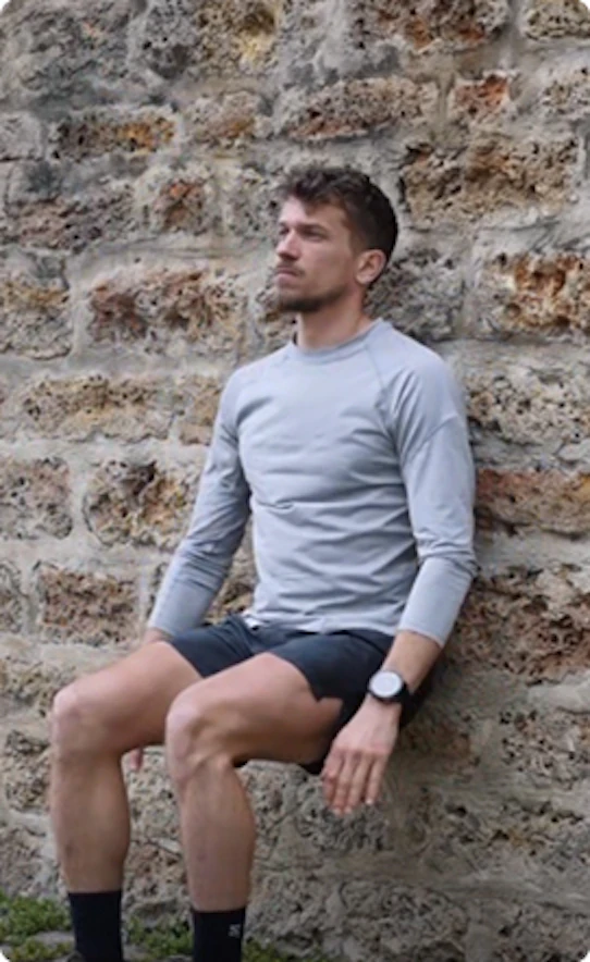 Mathieu Blanchard en position de chaise pour simuler la fatigue musculaire d'un effort de montée en trail running