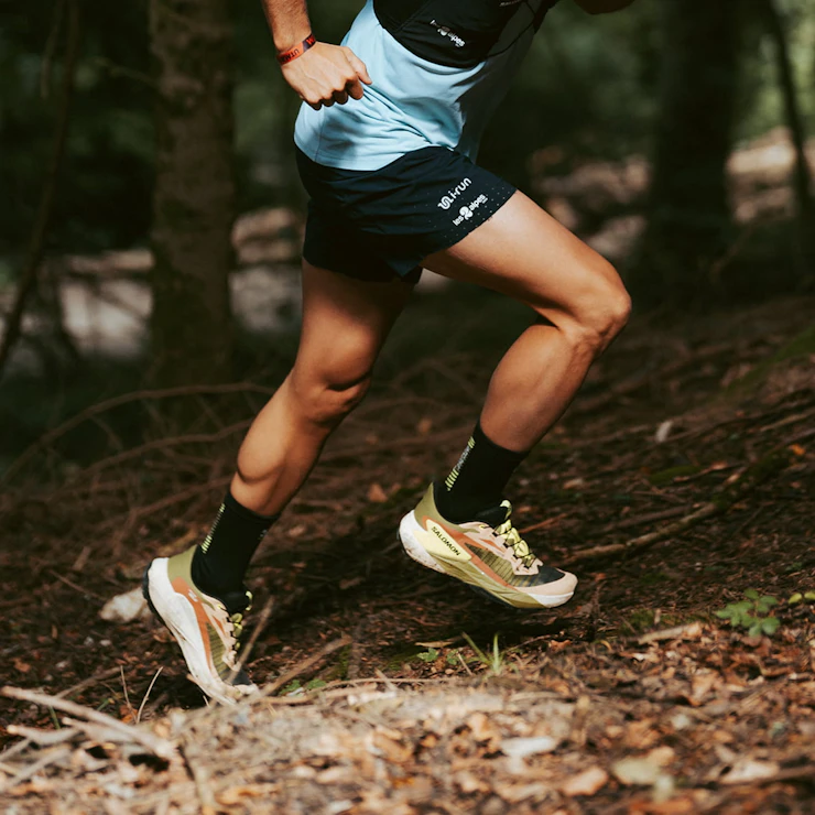 Gros plan sur les jambes de Mathieu Blanchard pendant un effort de trail de running en montée vue de profil