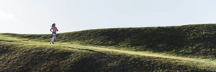 femme court sur une colline verdoyante
