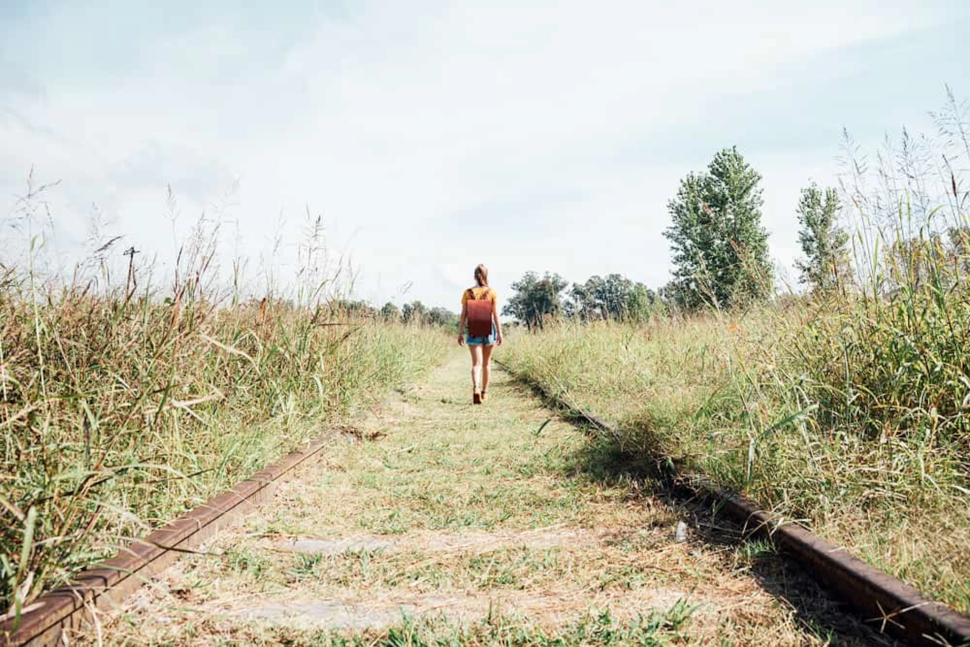femme marche sur une longue voie ferrée