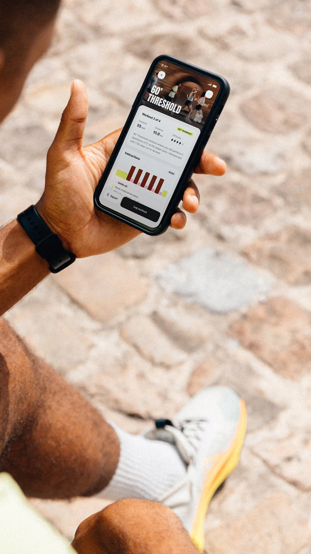 A runner sitting down, reading his daily workout on the Campus Coach app
