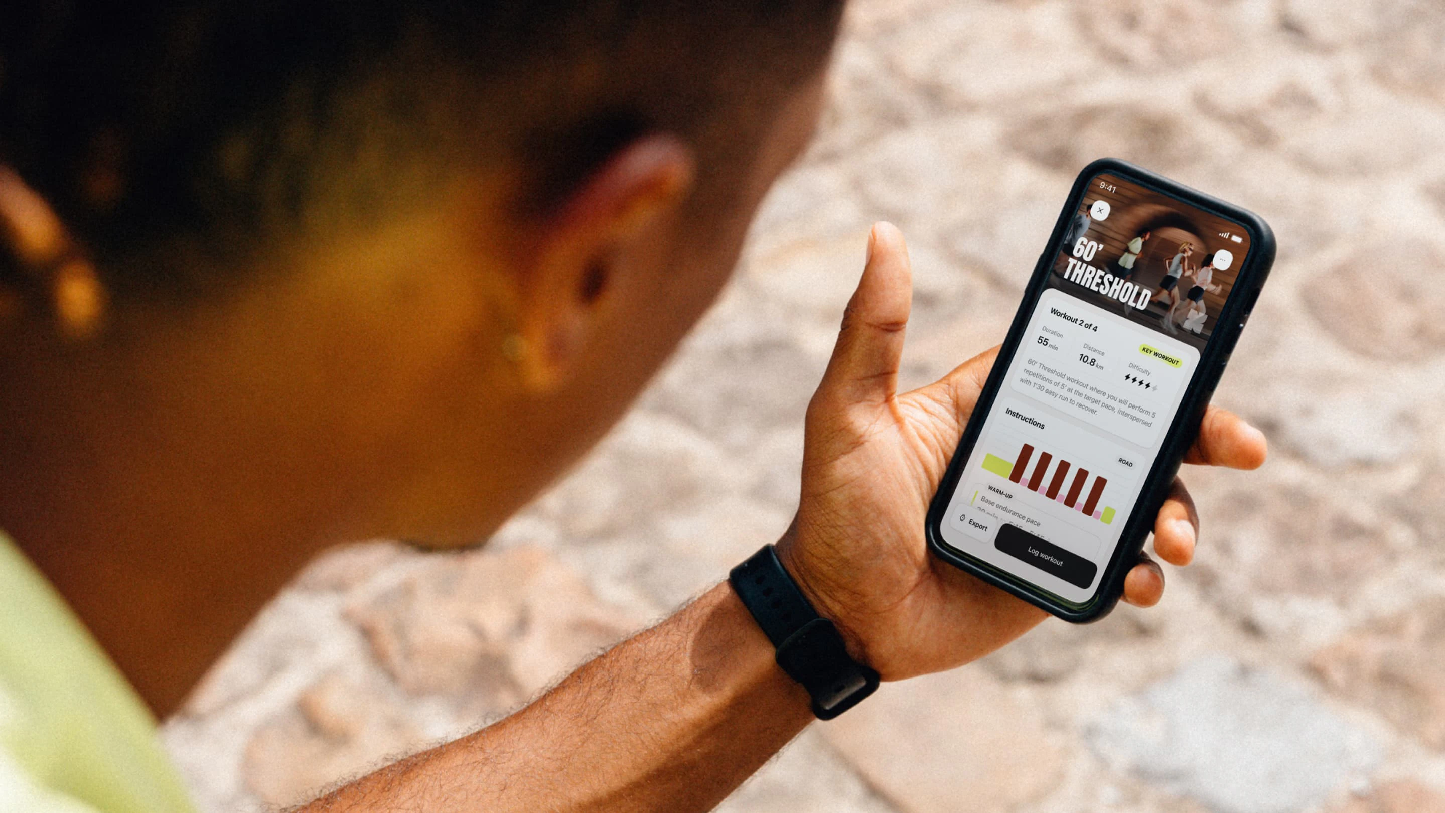 A runner sitting down, reading his daily workout on the Campus Coach app