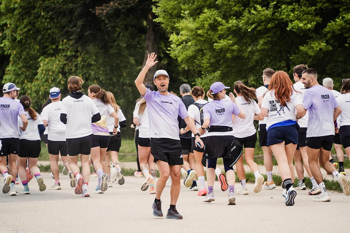 peloton de coureurs de dos avec un qui est de face et salue