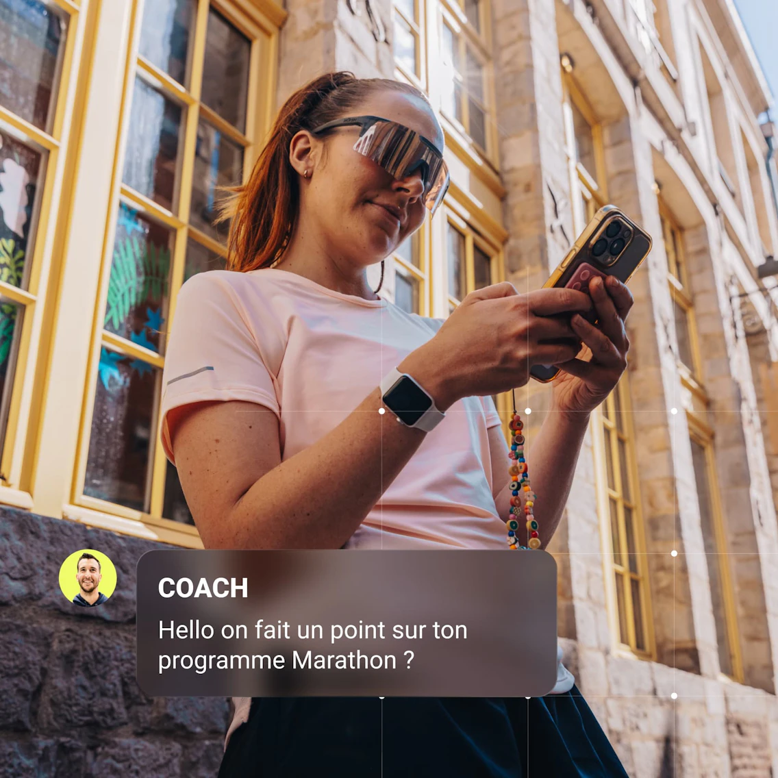 Coureuse habillée en tenue de running utilisant son smartphone