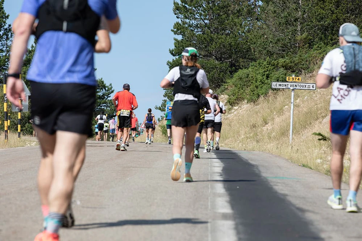 coureurs de dos sur une route avec un panneau D974 Le Mont Ventoux