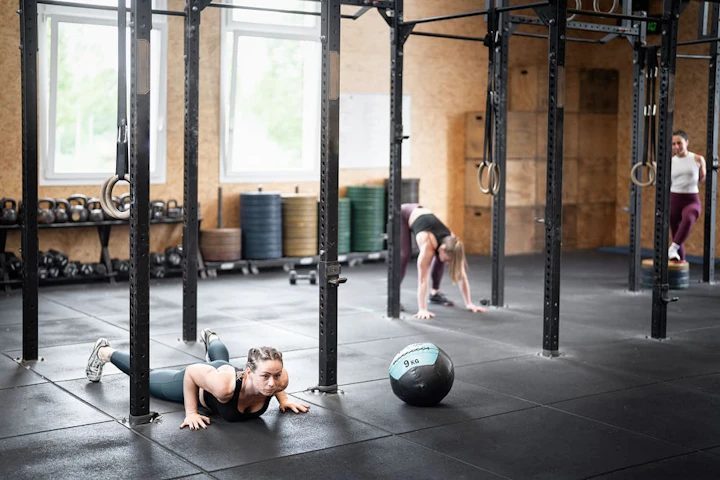 trois femmes en tenue de sport s'entraînent dans une salle