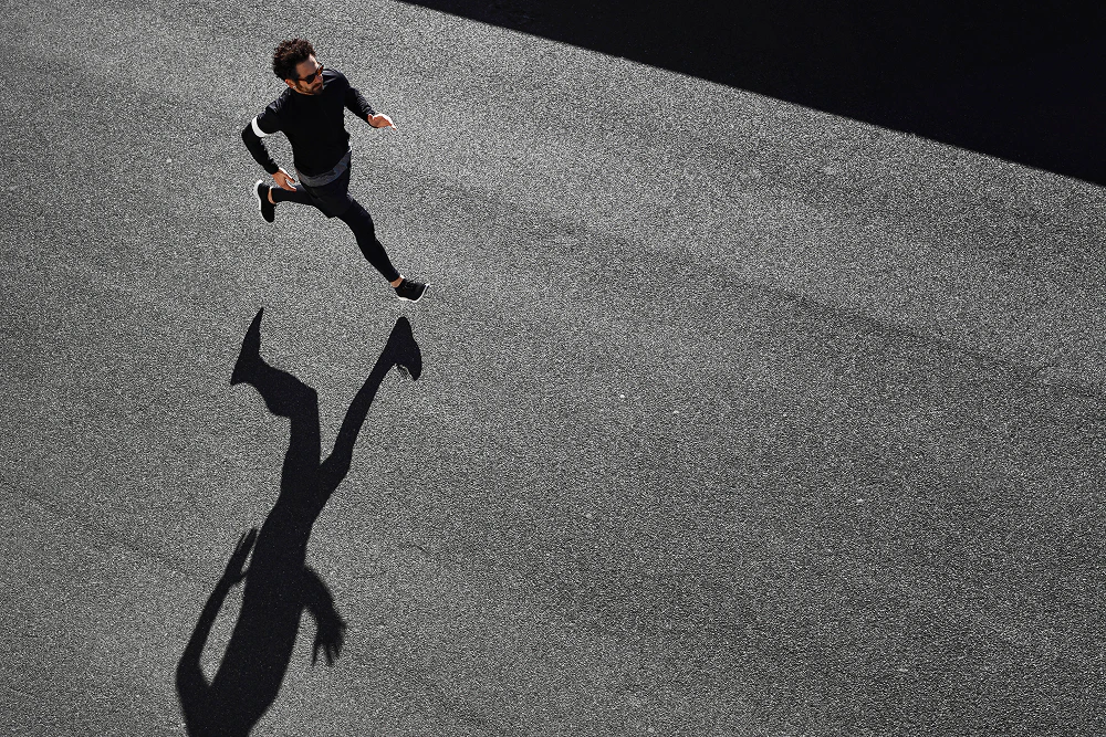 Un homme en contre-bas court sur le bitume