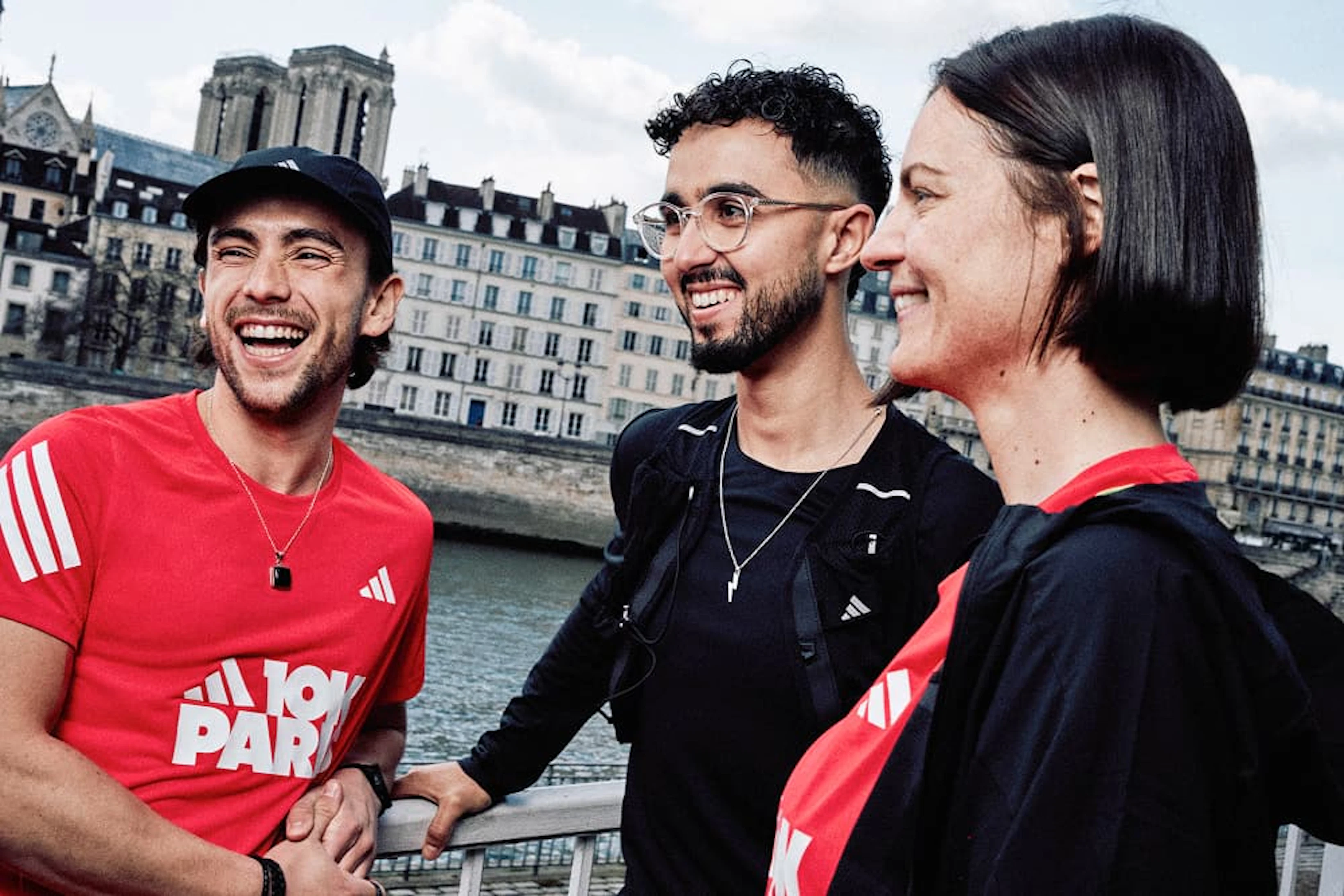 deux hommes et une femme sourient avec le maillot du adidas 10K paris