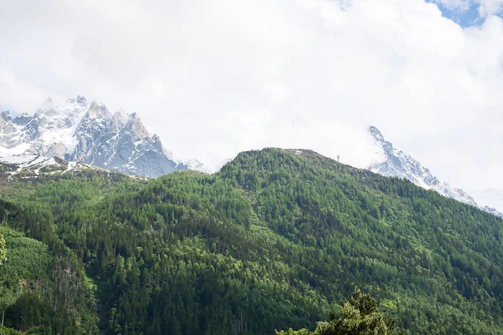 montagnes enneigées derrière des montagnes vertes - courses Rhône Alpes
