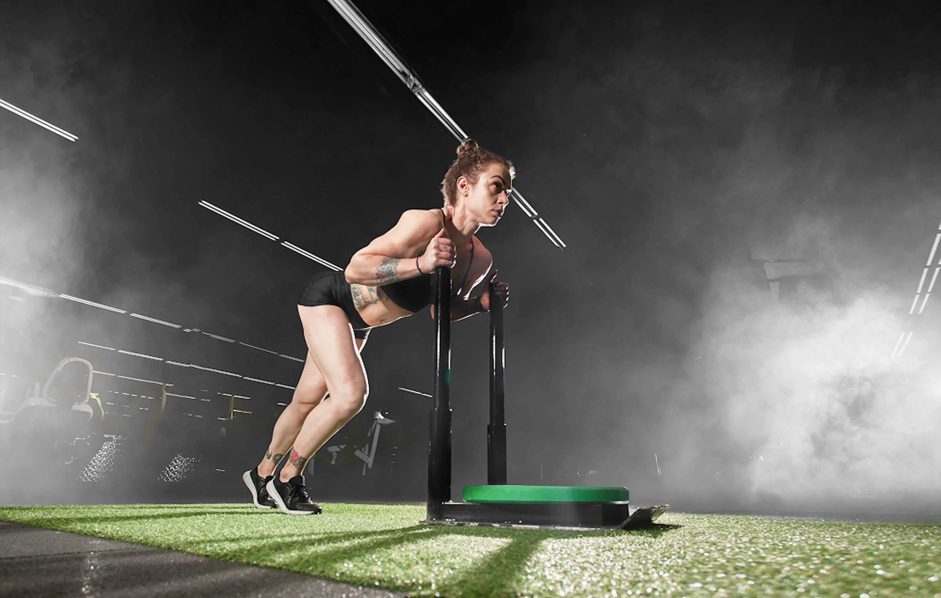 Femme en tenue de sport pousse un sled push