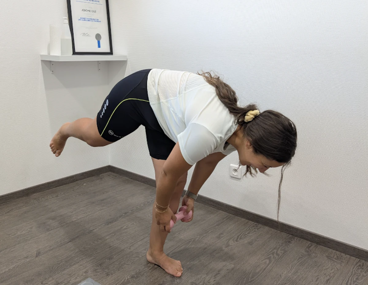 femme se penche en avant en équilibre sur un pied