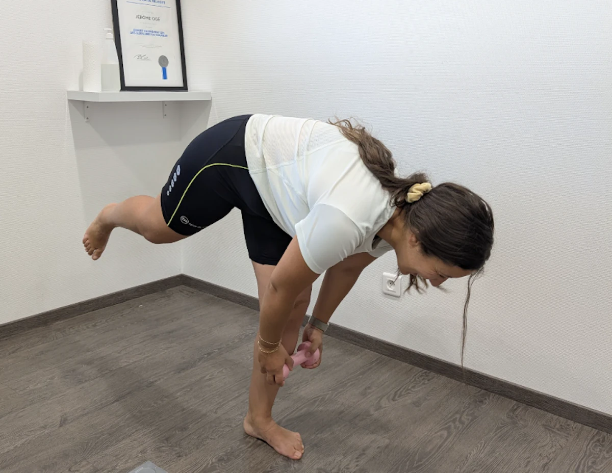 femme se penche en avant en équilibre sur un pied